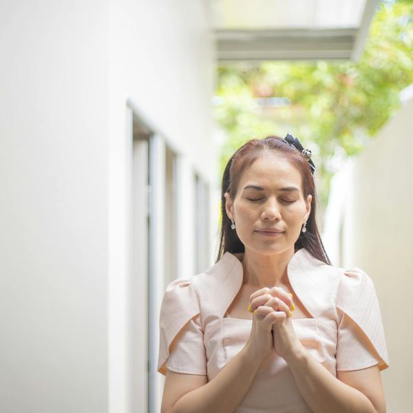 A calm woman meditating peacefully with a serene expression.